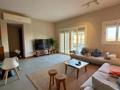 a living room with a couch and a table at Scenic 2BR Ground Floor - Free Pool& Lagoon Access In ElGouna in Hurghada