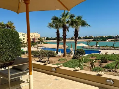 a view of a resort with palm trees and a pool at Scenic 2BR Ground Floor - Free Pool& Lagoon Access In ElGouna in Hurghada