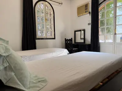 a bedroom with two beds and a window at Ramla Palace House in Luxor
