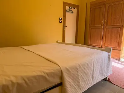 a bedroom with a bed with a white blanket on it at Ramla Palace House in Luxor