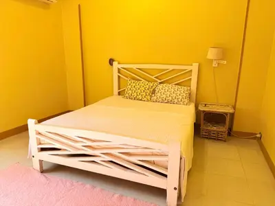 a bedroom with a white bed in a yellow room at Ramla Palace House in Luxor