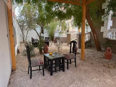 a patio with two chairs and a table and a table and chairs at Ramla Palace House in Luxor