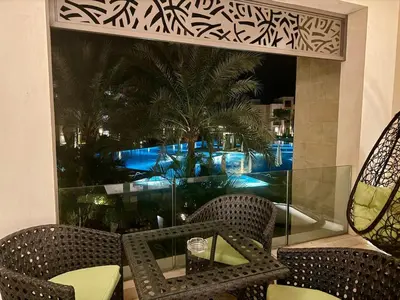 a patio with two chairs and a table and a window at Cozy 2BR Plus Nanny - Free Beach&Pool In Mangroovy ElGouna in Hurghada