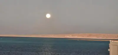 a moon over a body of water at ROOF TOP 12 Seaview in Hurghada