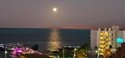 a full moon rising over the ocean at night at ROOF TOP 12 Seaview in Hurghada