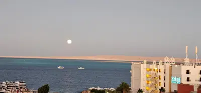 two boats in the water next to a building at ROOF TOP 12 Seaview in Hurghada
