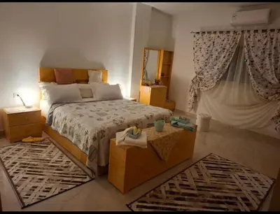 a bedroom with a bed and a table and a mirror at Villa Azad Elkber in Quseir