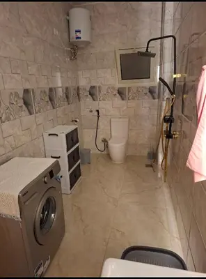 a bathroom with a washing machine and a toilet at Villa Azad Elkber in Quseir