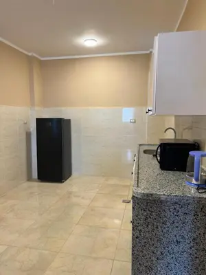 a kitchen with a counter and a black refrigerator at Orange guest house in Luxor