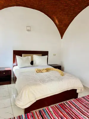 a bedroom with a large bed with a towel on it at Orange guest house in Luxor