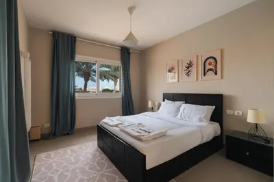 a bedroom with a large bed and a window at Joubal 2BR Lagoon View Residence in Hurghada