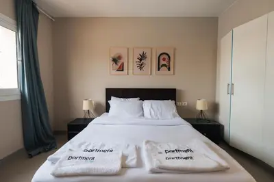 a bedroom with a large bed with two towels on it at Joubal 2BR Lagoon View Residence in Hurghada