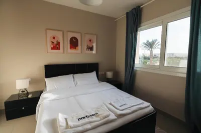 a bedroom with a large bed with towels on it at Joubal 2BR Lagoon View Residence in Hurghada