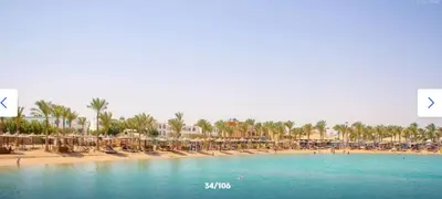 a beach with a bunch of umbrellas and chairs at قرية ميراج باي للراحة والانسجام in Hurghada