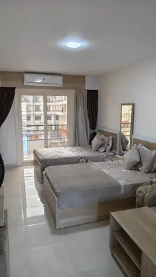 a large bedroom with two beds and a large window at Holiday appartment in Tiba Golden in Hurghada