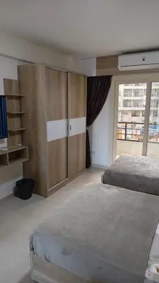 a bedroom with two beds and a large window at Holiday appartment in Tiba Golden in Hurghada