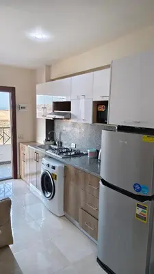a kitchen with a washer and a white refrigerator at Holiday appartment in Tiba Golden in Hurghada