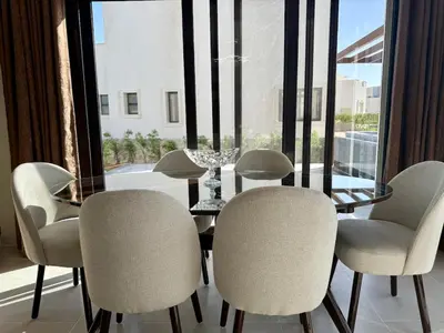 a dining room with a table and chairs and a window at Sunny 4BR Villa Plus Nanny With Private Heated Pool And Jacuzzi In ElGouna in Hurghada