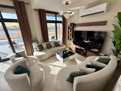 a living room with two couches and a television at Sunny 4BR Villa Plus Nanny With Private Heated Pool And Jacuzzi In ElGouna in Hurghada