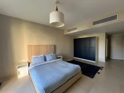 a bedroom with a large bed with a blue blanket at Mangroovy -2BR GF Hacienda House Pool & Beach access in Hurghada