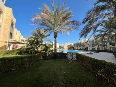 a resort yard with palm trees and a pool at Mangroovy -2BR GF Hacienda House Pool & Beach access in Hurghada