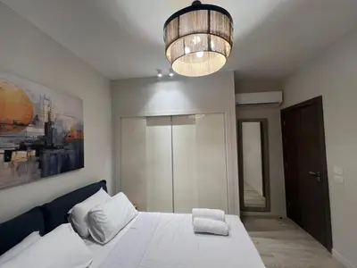 a bedroom with a white bed and a chandelier at Ancient Hill 3BR Roof & Private Mini Pool in Hurghada