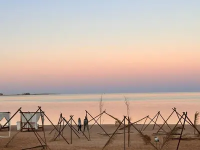 two people walking on the beach at sunset at Luxury apartment- Sahl Hasheesh- Gravity Hotel in Hurghada