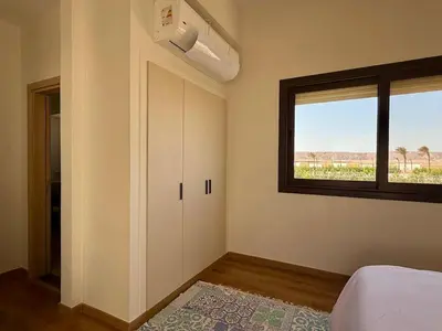 a bedroom with a bed and a window and a door at Premium 3BR Plus Nanny Villa -Free Pool And Lagoon Access In ElGouna in Hurghada