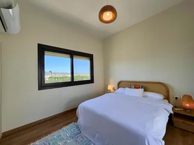 a bedroom with a large bed and a window at Premium 3BR Plus Nanny Villa -Free Pool And Lagoon Access In ElGouna in Hurghada