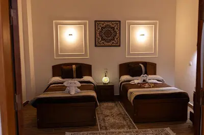 two twin beds in a room with at Horus Garden House in Luxor