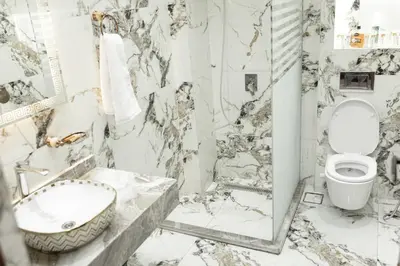 a marble bathroom with a toilet and a sink at Horus Garden House in Luxor