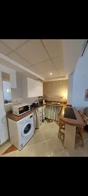 a kitchen with a stove and a table in it at 1 Bedroom in Port Ghalib