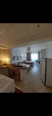 a kitchen and living room with a table and a refrigerator at 1 Bedroom in Port Ghalib