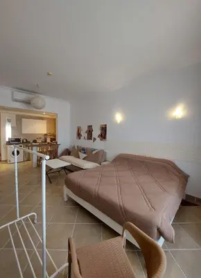 a bedroom with a large bed and a kitchen at 1 Bedroom in Port Ghalib