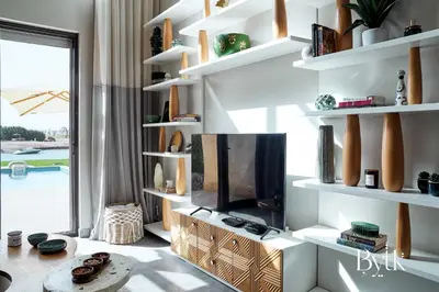 a living room with a tv and white shelves at BYTK - La Serena in Hurghada