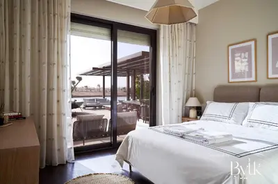 a bedroom with a bed and a balcony with a patio at BYTK - La Serena in Hurghada