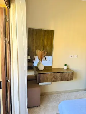 a bedroom with a bed with a desk and a mirror at Aldau Heights Hurghada Prestige Spacious Hotel-Style Poolview 1BR in Hurghada
