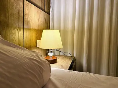 a bedroom with a bed with a lamp and a curtain at Aldau Heights Hurghada Prestige Spacious Hotel-Style Poolview 1BR in Hurghada