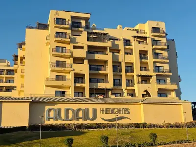 a large yellow building with a sign in front of it at Aldau Heights Hurghada Prestige Spacious Hotel-Style Poolview 1BR in Hurghada
