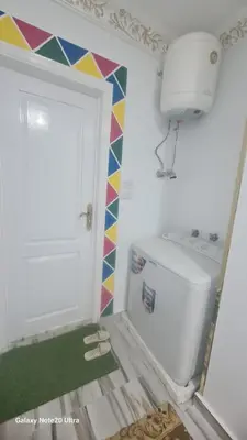 a laundry room with a washing machine and a door at Aladino Nubian Soul in Aswan
