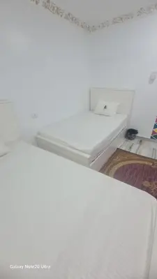 a white bed in a room with a mirror at Aladino Nubian Soul in Aswan