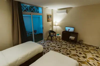 a hotel room with two beds and a desk and a window at The View Luxor hotel in Luxor