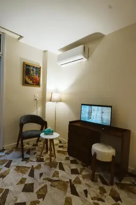 a living room with a tv and a chair and a table at The View Luxor hotel in Luxor
