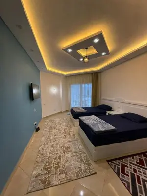 a bedroom with two beds and a rug at Diamond resort Hurghada 7 in Hurghada