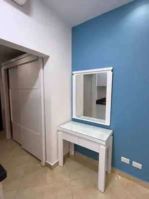 a white dressing table with a mirror on a blue wall at Diamond resort Hurghada 7 in Hurghada