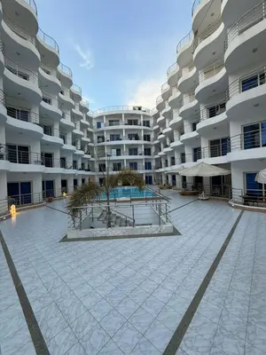 a large apartment building with a courtyard with a pool at Diamond resort Hurghada 7 in Hurghada