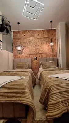 two beds in a room with a wall at Woori Duri \ud658\ub300\ub97c \uc704\ud574 in Aswan