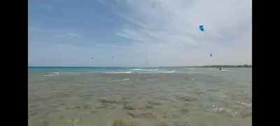 a person is flying a kite in the ocean at Relax near the sea, one bedroom flat in Hurghada