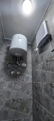 a bathroom with a toilet and a television on a tiled floor at Relax near the sea, one bedroom flat in Hurghada