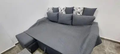 a bed with blue sheets and pillows on it at Relax near the sea, one bedroom flat in Hurghada